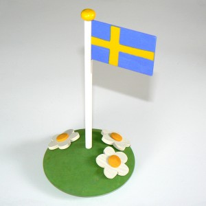 Sommerliche Tischdeko aus Holz: schwedische Flagge auf Blumenwiese